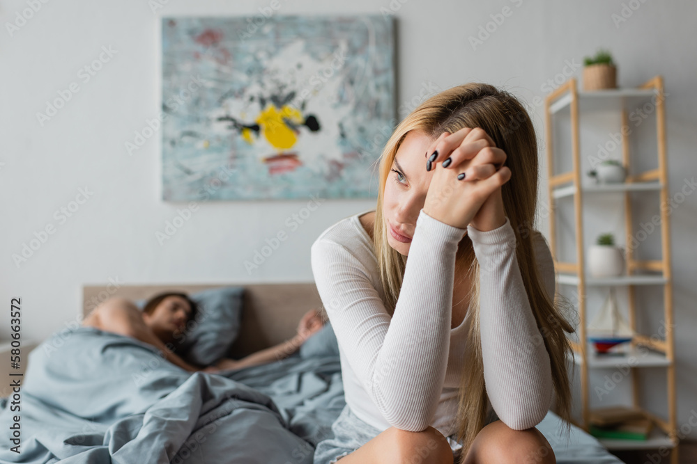 worried young woman sitting on bed after one night stand with stranger