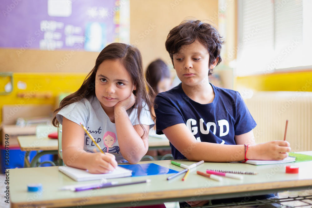 Caucasian boy and girl at school. Classmates learning together. Primary education and child development.