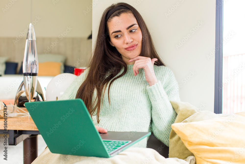 pretty young woman working at home with a laptop. house interior design pretty young woman working at home with a laptop. house interior design