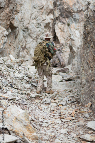 Soldat armé en uniforme progressant dans les gravats 