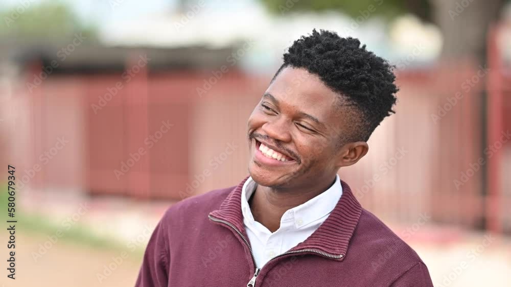 Closeup portrait of African man on a street. Face of handsome model laughing at a joke cropped. Headshot of cheerful man making facial expression stock video Closeup portrait of African man on a street. Face of handsome model laughing at a joke cropped. Headshot of cheerful man making facial expression stock video