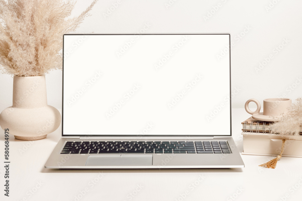 Mockup laptop with white screen on the table with vase, pampas grass and decorations. Aesthetic background for study, cozy home office, promotion, social media - obrazy, fototapety, plakaty 