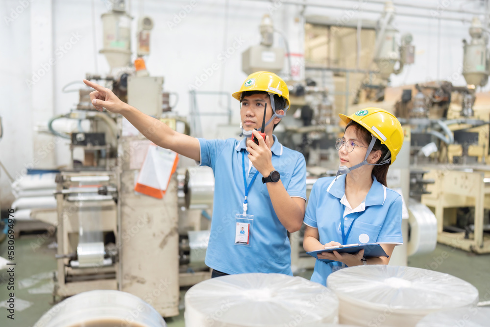 Asian managers and engineers working in an industrial factory have a machine Check business systems and plan projects. point the finger at the product Wear a helmet and uniform. Asian managers and engineers working in an industrial factory have a machine Check business systems and plan projects. point the finger at the product Wear a helmet and uniform.