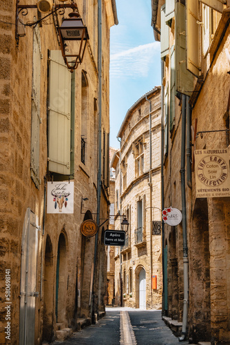 Fototapeta Naklejka Na Ścianę i Meble -  Quaint street of Rue Alfred Sabatier with medieval stone facades in the old town of Pezenas in the south of France (Herault).