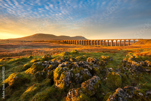 Golden morning light on Ribblehead Viaduct at sunrise. Yorkshire Dales, UK.