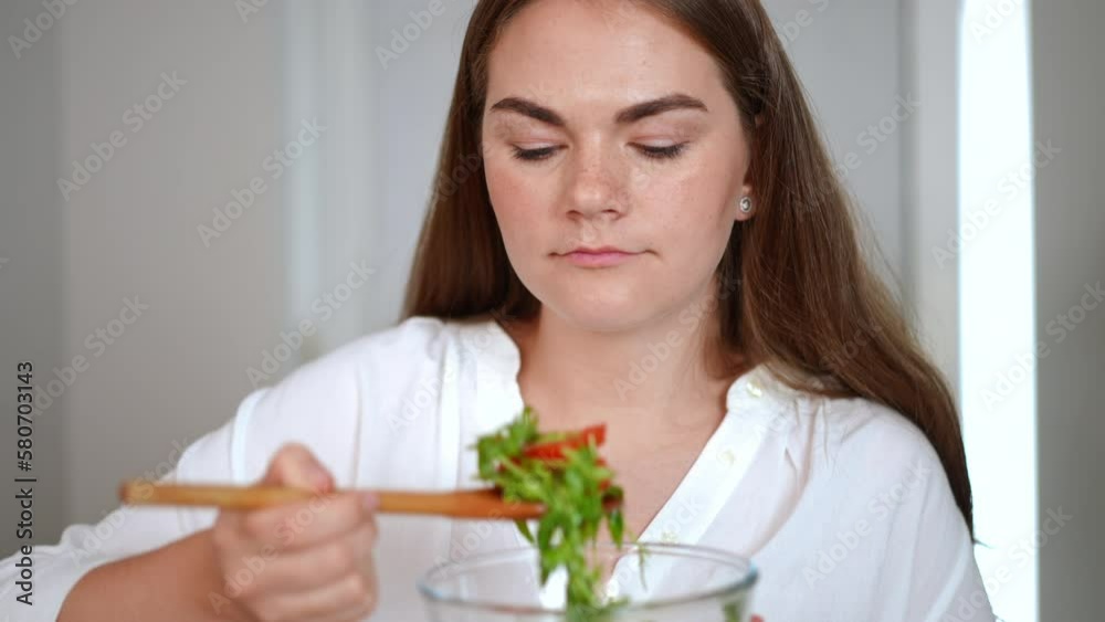 Portrait of confident gorgeous Caucasian woman smelling salad smiling and looking at camera in slow motion. Happy satisfied housewife posing at home with healthful organic vegetarian dish Portrait of confident gorgeous Caucasian woman smelling salad smiling and looking at camera in slow motion. Happy satisfied housewife posing at home with healthful organic vegetarian dish