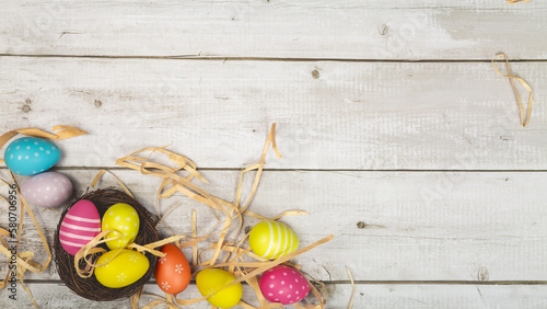 Easter eggs painted in pastel colors on white wooden background. Easter concept