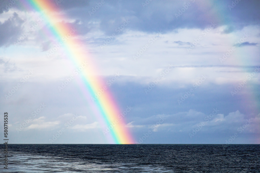 Part of a bright colorful rainbow in the open sea.