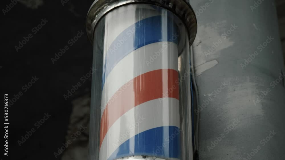 Rotating barbershop pole close up. Logo of barber shop, symbol in retro style.