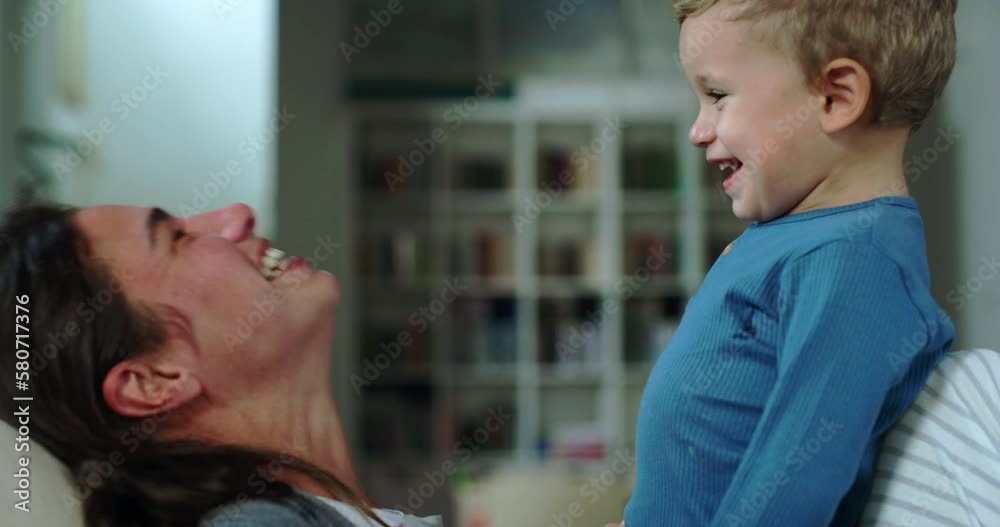 Portrait of Young Woman Playing with her Little Boy During Evening in the Living Room. Little Cute Male Toddler Bonding with his Mom, Enjoying his Time and Laughing. Mother Son Quality Time Portrait of Young Woman Playing with her Little Boy During Evening in the Living Room. Little Cute Male Toddler Bonding with his Mom, Enjoying his Time and Laughing. Mother Son Quality Time