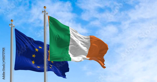 The flags of Ireland and the European Union fluttering together on a clear day