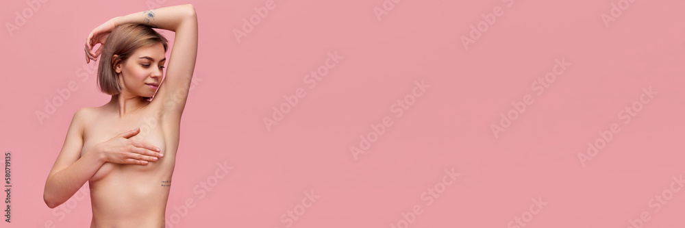 Fototapeta premium Young woman examining her breast. Concept of female health, annual medical exam, mammography, breast cancer prevention