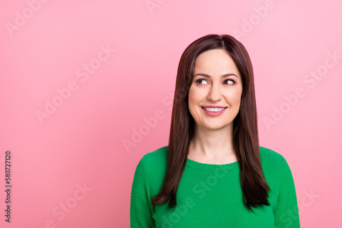 Photo of dreamy adorable woman wear green sweater looking empty space isolated pink color background