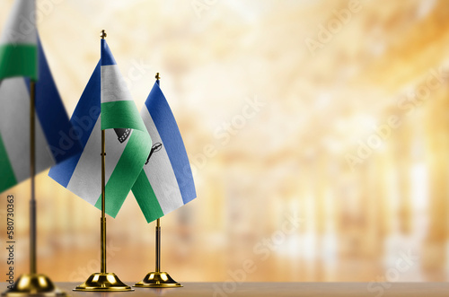 Small flags of the Lesotho on an abstract blurry background