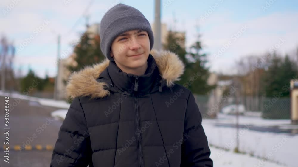 Portrait confident boy looking away warm clothes at street. Handsome student walking outside at winter day. Young people lifestyle concept Portrait confident boy looking away warm clothes at street. Handsome student walking outside at winter day. Young people lifestyle concept