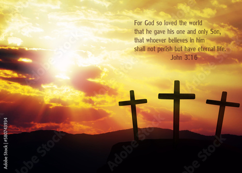 Close up of tree isolated black cross on the hill over blurred sunset sky background  with word from bible verses,Romans 5:6 , Christian background with copy space.