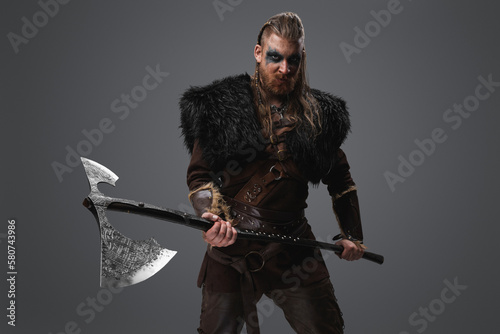 Shot of fearful barbarian from north dressed in black fur and holding huge axe.