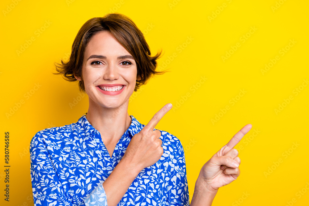 Photo of excited pretty young lady wear print shirt showing two fingers empty space isolated yellow color background Photo of excited pretty young lady wear print shirt showing two fingers empty space isolated yellow color background