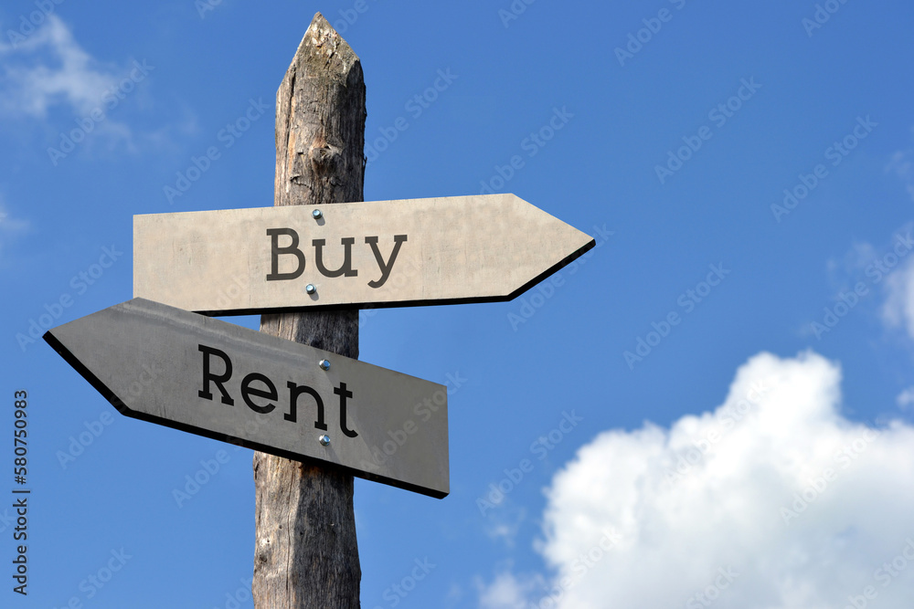 Buy or rent - wooden signpost with two arrows, sky with clouds Buy or rent - wooden signpost with two arrows, sky with clouds