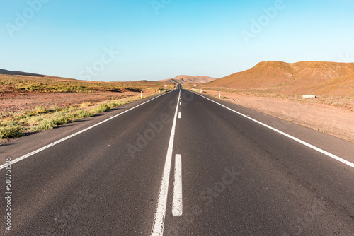 Empty road through desert valley in Fuerteventura island, Spain