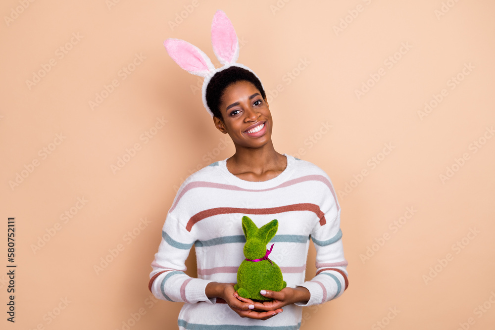 Photo of pretty shiny trans human dressed pullover hare headband holding easter rabbit isolated beige color background