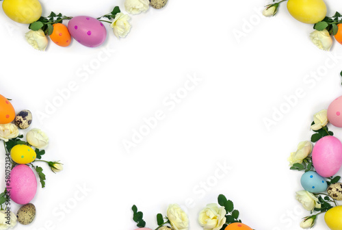 Easter decoration. Easter frame of colored easter eggs and white roses flowers on white background with space for text. Top view, flat lay