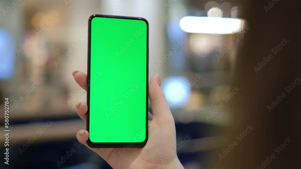 Mall. Use green screen for copy space closeup. Chroma key mock-up on smartphone in hand. hold mobile phone and looking photos or pictures Mall. Use green screen for copy space closeup. Chroma key mock-up on smartphone in hand. hold mobile phone and looking photos or pictures
