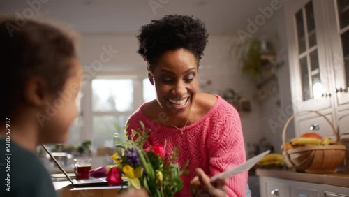 Boy with Down Syndrome giving mother bouquet and card on Mother's Day
