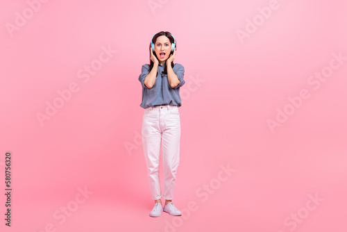 Full length body photo of overjoyed funny excited meloman listen new rap album kanye west music headphones isolated on pink color background photo