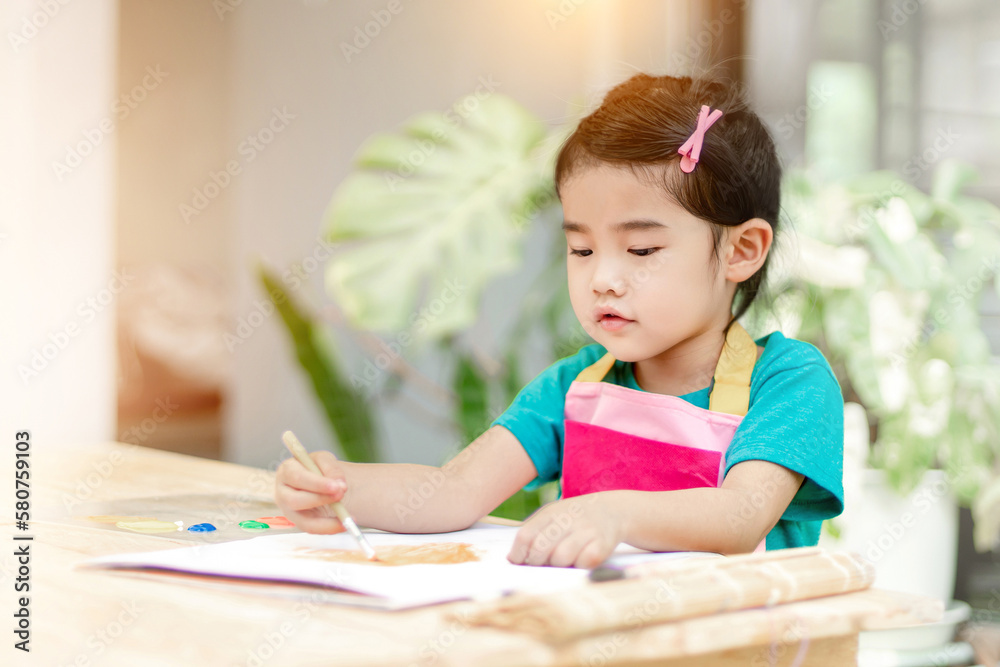 Asian girl in Colorful dress take brush painting on white paper.Focus with extremely shallow DOF .Soft style Asian girl in Colorful dress take brush painting on white paper.Focus with extremely shallow DOF .Soft style