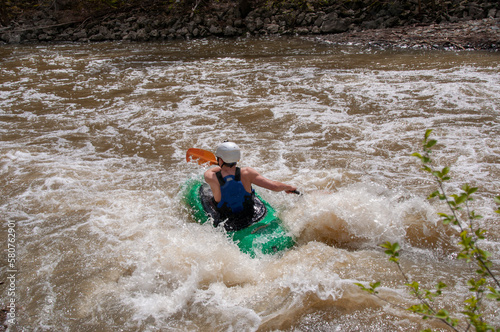 Fototapeta Naklejka Na Ścianę i Meble -  A man white water kayaks on a small river