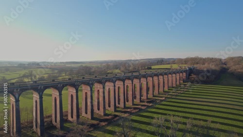 Train speeds across magnificent viaduct at sunset