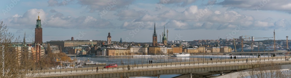 Panorama, down town view the long bridge Västerbron, Town City Hall, the old town islands with churches at the bay Riddarfjärden, a snowy sunny spring day in Stockholm