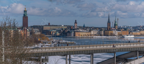 Panorama, down town view the long bridge Västerbron, Town City Hall, the old town islands with churches at the bay Riddarfjärden, a snowy sunny spring day in Stockholm