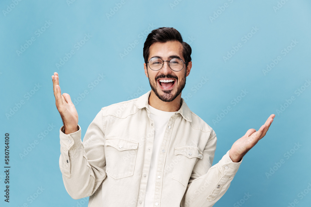 Fototapeta premium Portrait of a stylish man smile with teeth and happiness in glasses for farsightedness and myopia, on a blue background in a white T-shirt, space space