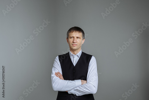 Male portrait in a classic shirt and vest on a gray background