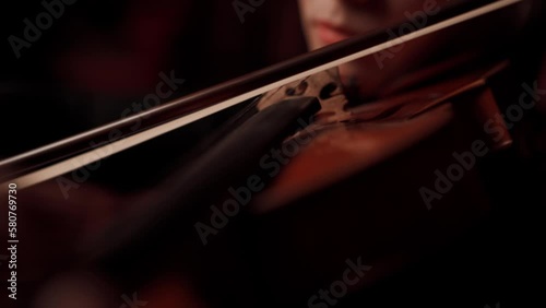 Violin playing violinist musician. Woman classical musical instrument player on black. Violinist playing violin on dark background.