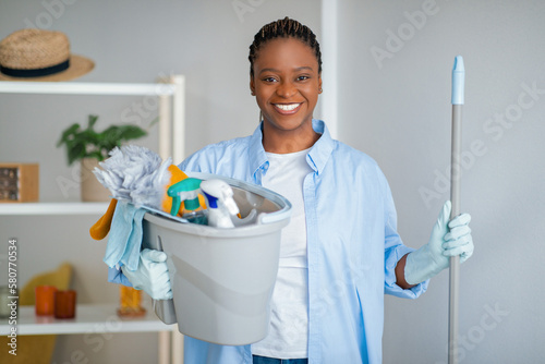Friendly african american lady maid ready for cleaning house photo