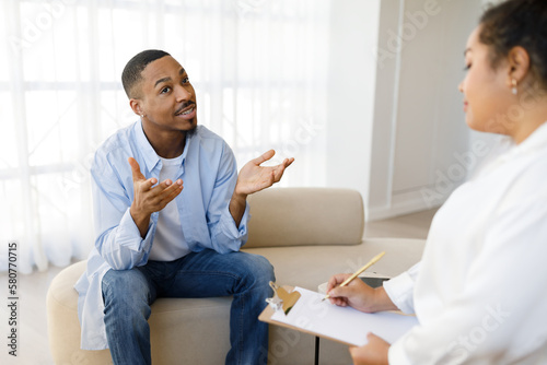 Handsome black guy attend therapy session with psychologist
