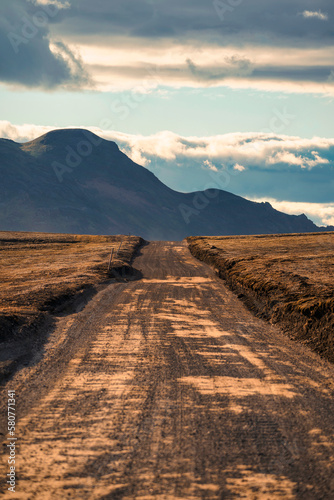 Scenic view of dirt road and volcanic mountain on remote wilderness among Icelandic Highlands