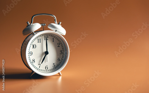 White alarm clock on brown background isolated.