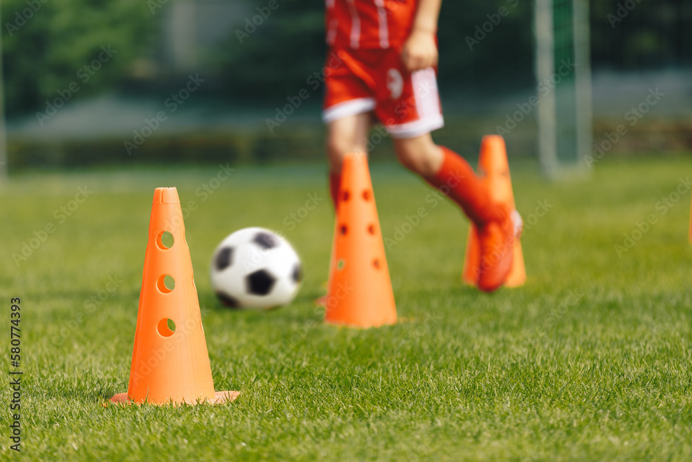 Obraz premium Football Training Background. Orange Practice Cone. Player Running Ball in Slalom Drill in Blurred Background. Sports Summer Camp for Soccer Teams