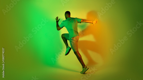 African American Male Runner Running Training Over Green Neon Background