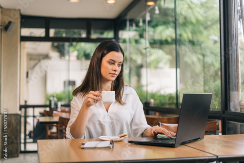 Thinking about how to take the business to technological heights. Screenshot of an attractive young businesswoman working in her office holding a cup of coffee