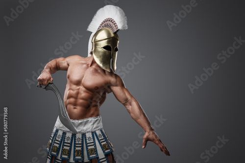 Portrait of shirtless greek soldier from past with strong body holding sword. photo