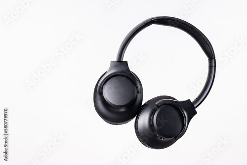 Black headband headphones to listen to music in free time, doing sports or traveling. Close-up on white background