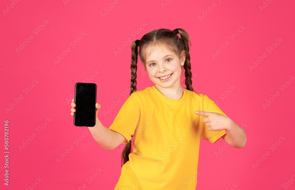 Smiling Little Girl Pointing At Blank Smartphone With Black Screen In Hand Smiling Little Girl Pointing At Blank Smartphone With Black Screen In Hand
