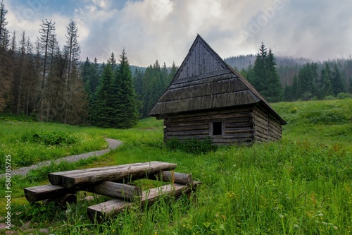 Tatra National Park in Poland. Poland  sitting in nature  wooden benches  grren meadow and cottage in Gasienicowa valley  Hala Gasienicowa  Hiking in nature near Kasprowy Wierch