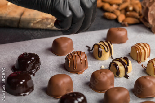 A confectioner decorates sweets with the help of a confectioner's bag