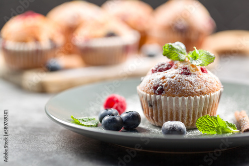Freshly baked muffins with powdered sugar and fresh berries